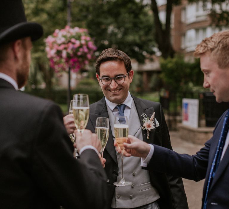 Groomsmen celebrating with Champagne for London wedding at the Royal Automobile Club