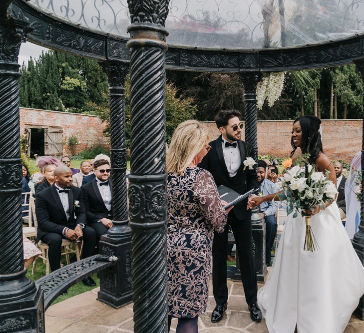 Bride and groom exchanging vows during an outdoor ceremony at Garthmyl Hall in Shropshire 