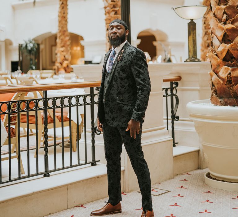 Groom in a black jacquard wedding suit with blue paisley tie 