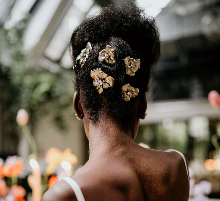 Bride with short afro hair wears clips in her updo as she sits at wedding table