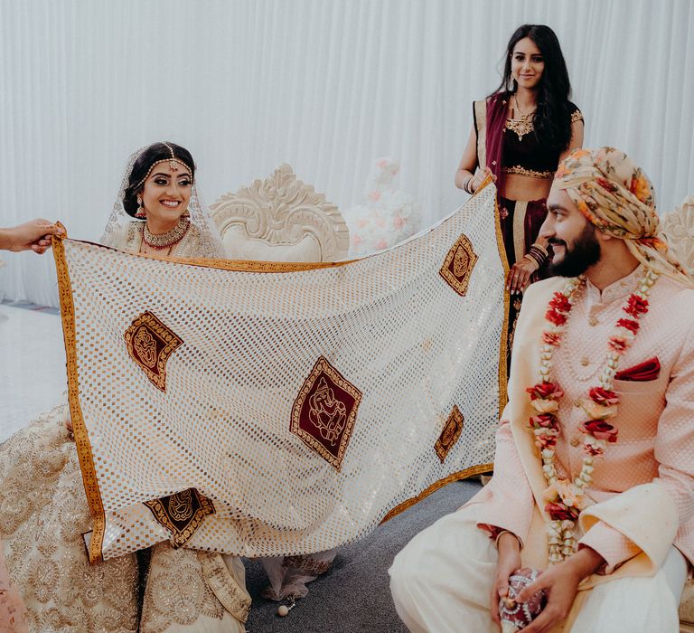 Curtain is held between the bride & groom 