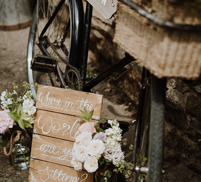 Rustic wedding table plan with bicycle and wooden signs in French