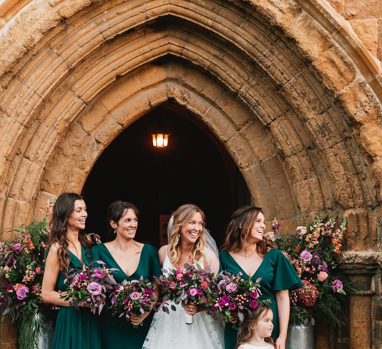 Bride stands with her bridesmaids wearing TH&TH bridesmaids dresses