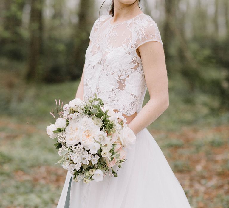 The bride standing in the wildflower meadows surrounding Chateau de la Ruche