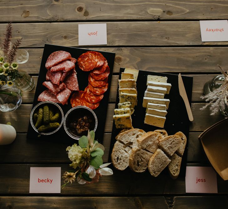 Top down view of charcuterie, cheese and bread on slate serving platters