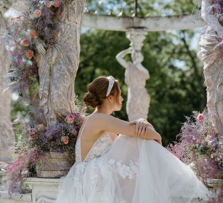 Bride wears lace floral gown with appliqué design 