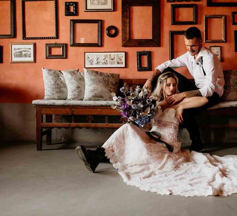 Bride clutches Hydrangea wedding flowers as she sits with groom