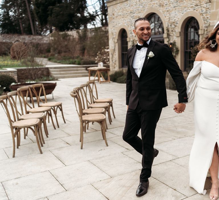 Outdoor ceremony at Middleton Lodge with groom in black tuxedo and bride in a strapless wedding dress with balloon sleeves and button detail