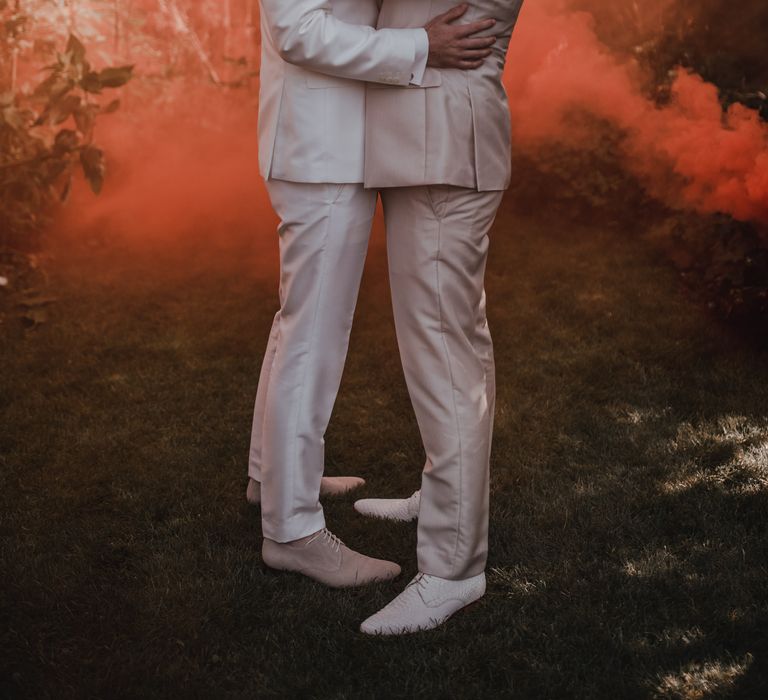 Grooms embrace at gay wedding