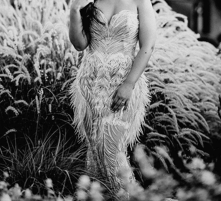 Black and white portrait of the bride in a strapless Biji La Maison de Couture wedding dress with feather design 