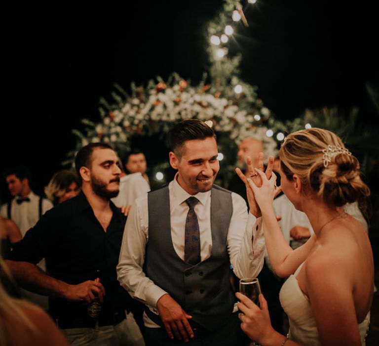 The groom showing his wedding ring to the bride who is holding his hand