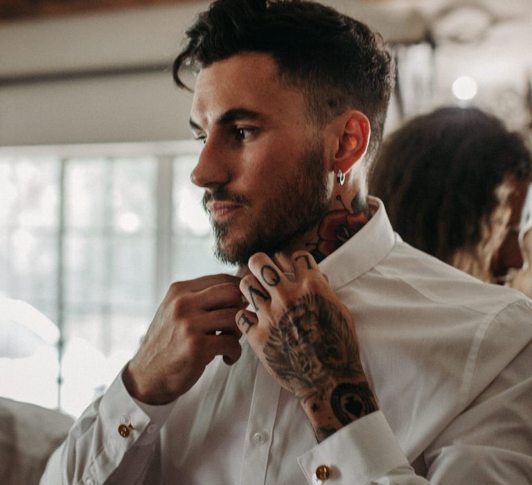 Groom with tattoos getting ready