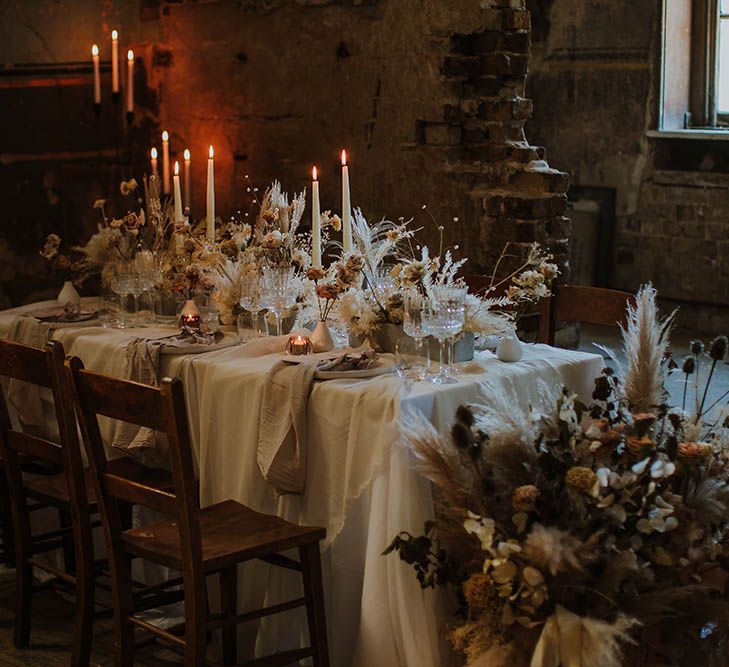 Intimate wedding table decor with dried and fresh flowers and taper candles 