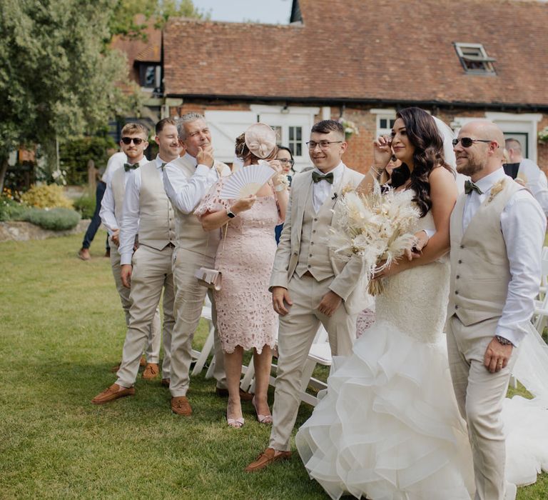 Outdoor wedding ceremony at Cooling Castle Barn with emotional bride in a fishtail wedding dress crying at the altar 