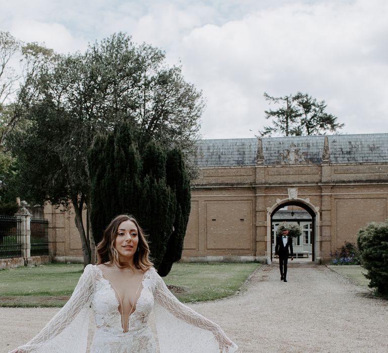 Bride in a lace wedding dress with embellishment, plunging neckline and bell sleeves