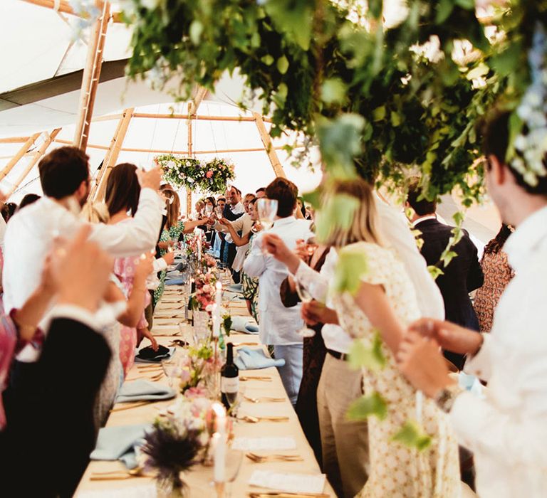 Table gives toast and raises their glasses to bride & groom