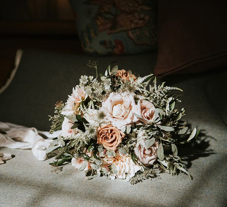 Romantic wedding bouquet tied with ribbon including ink and cafe au latte roses and foliage 