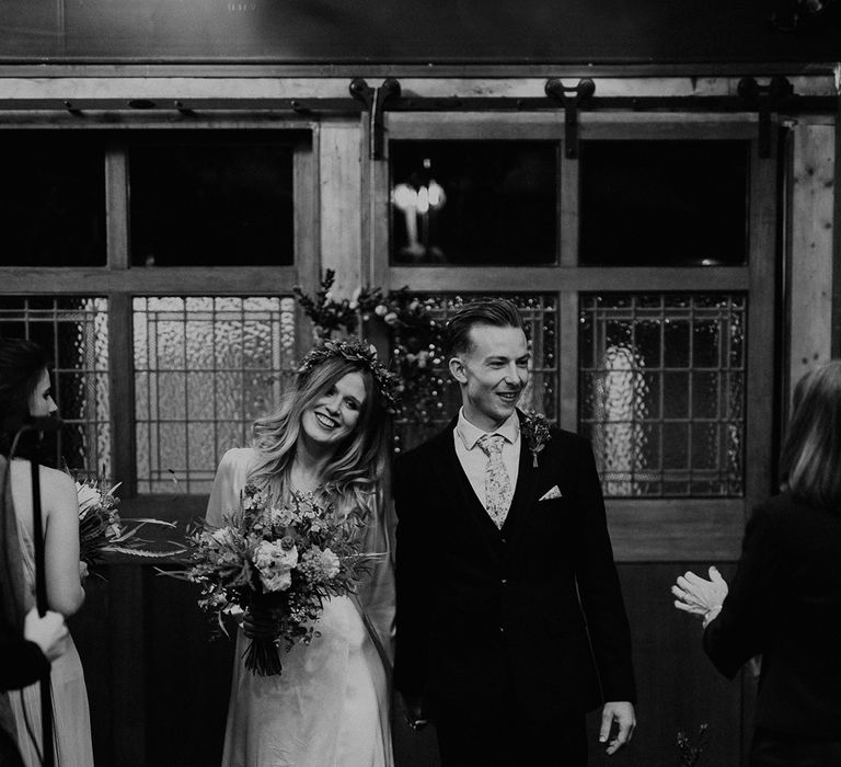 Bride & groom leave wedding ceremony in black and white image