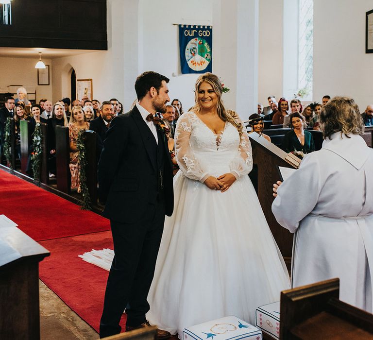 Church wedding ceremony with bride in a princess wedding dress with long sleeves