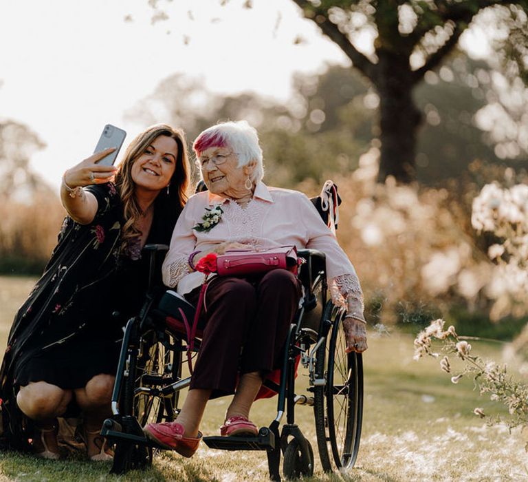 Wedding guests take a selfie during golden hour at Elmore Court wedding venue