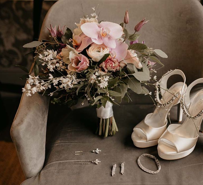 Pink and white mixed floral bouquet next to cream dune scrappy wedding heels and silver jewellery 