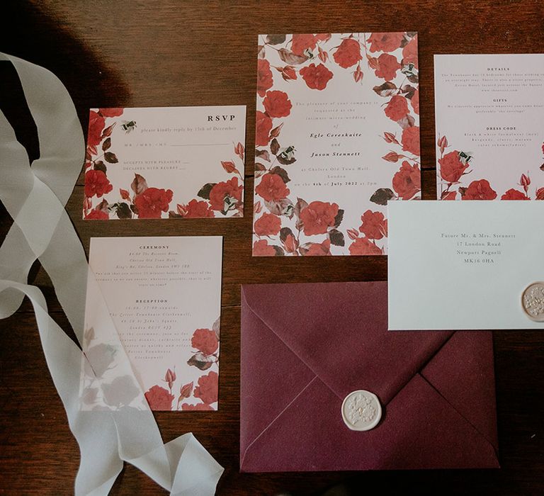 Red and pink wedding stationery suit flat lay with white wax seal and floral designs from Papier