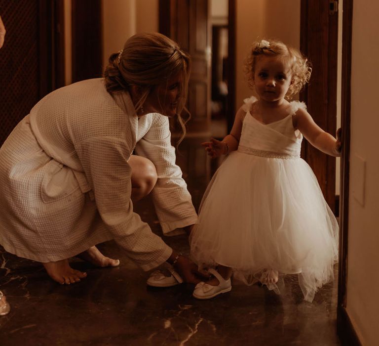 Flower girl wears white dress complete with ballerina net skirt and crossover top 