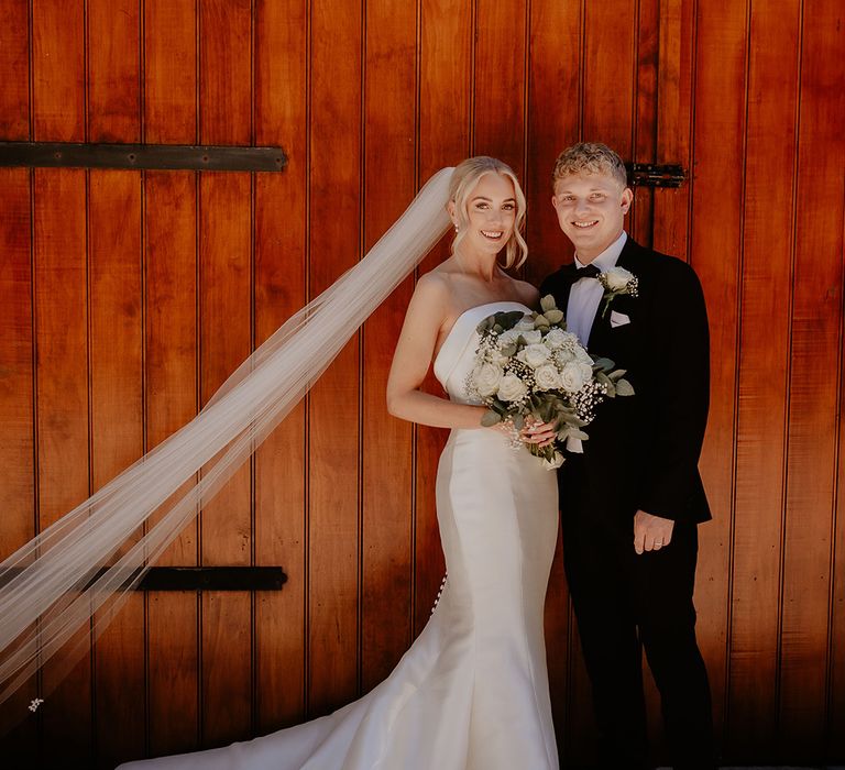 Bride and groom stand closely together for their couple portraits 