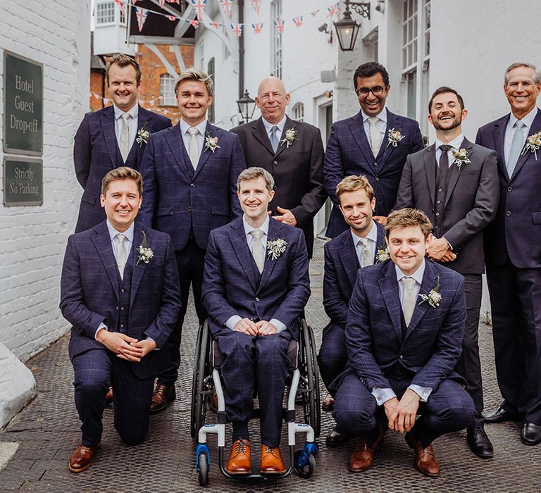 Groom with the groomsmen and wedding guests all in blue or grey wedding suits