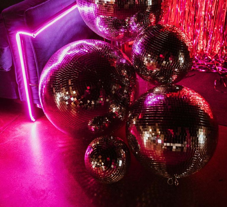 Neon lights and streamers with disco balls for fun and sparkly wedding decorations 