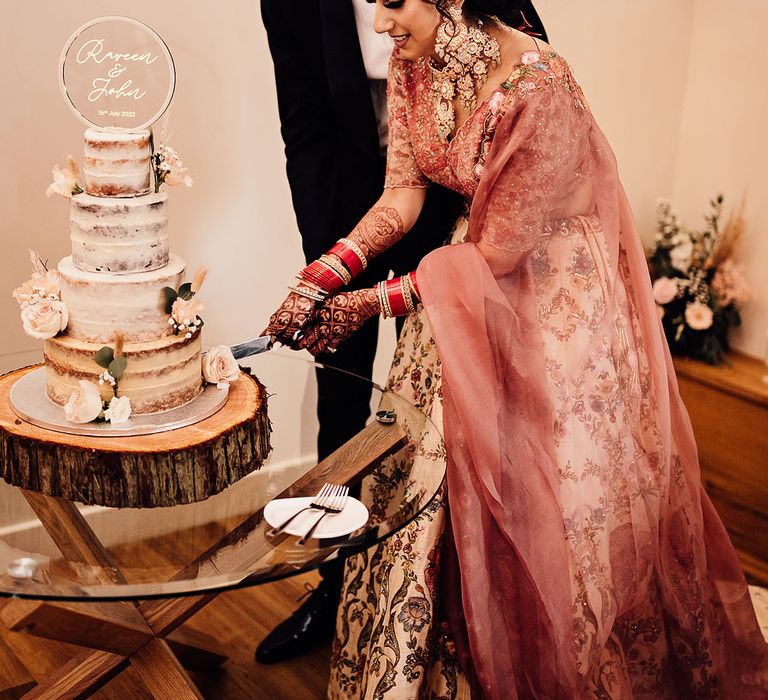 Bride & groom cut naked wedding cake during reception 