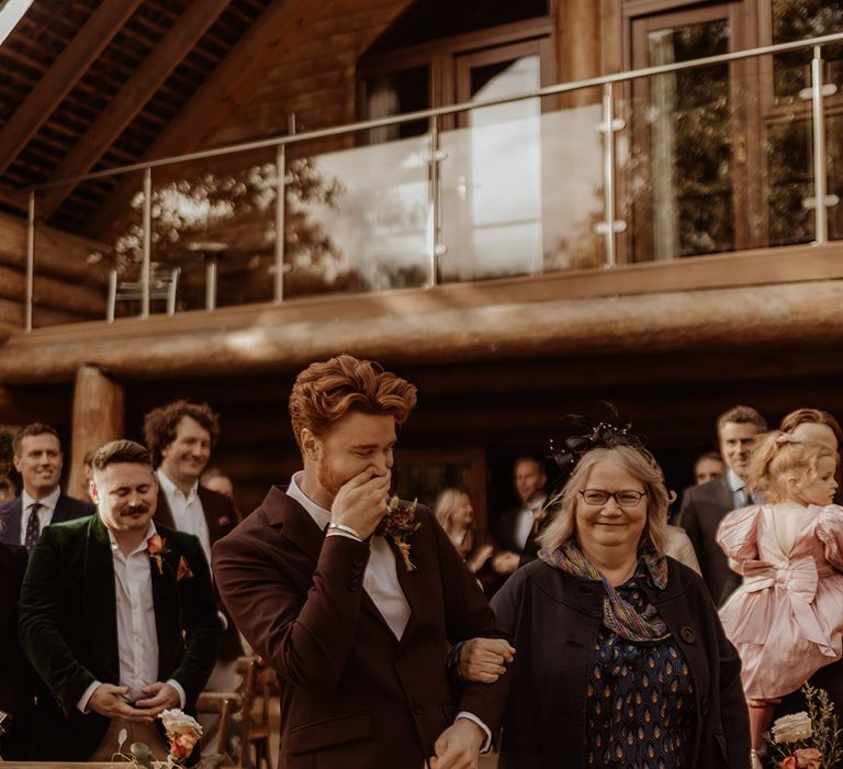 Mother walks groom down the aisle for the outdoor wedding at Hidden River Cabins