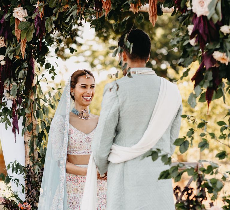 Bride wears pastel floral lehenga complete with statement necklace 