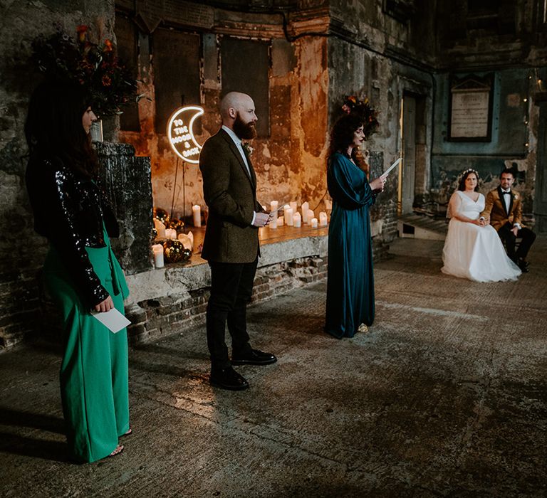 Bridesmaid in green satin dress does wedding reading during ceremony at The Asylum Chapel, a unique wedding venue in London