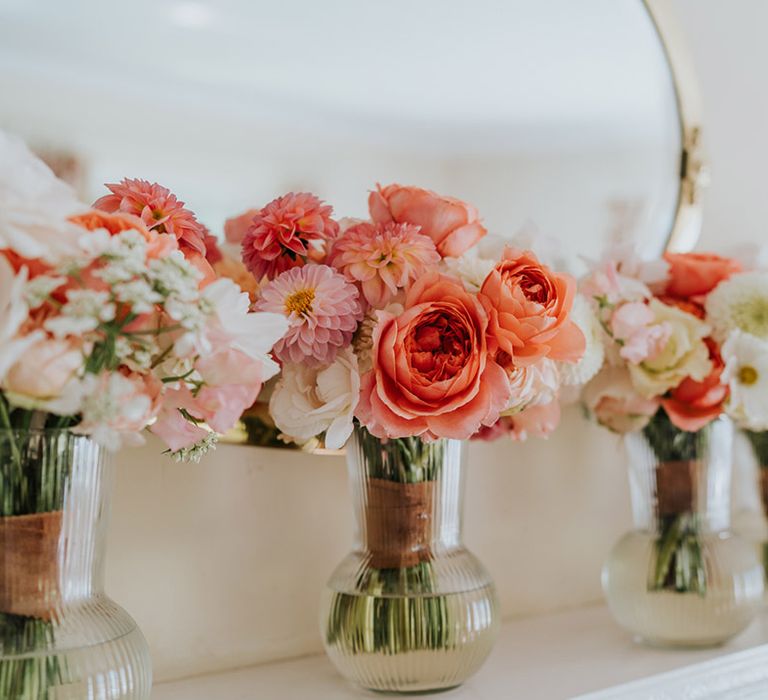 The bridesmaid's bouquets with pink, coral and white wedding flowers including peonies, dahlias and roses 