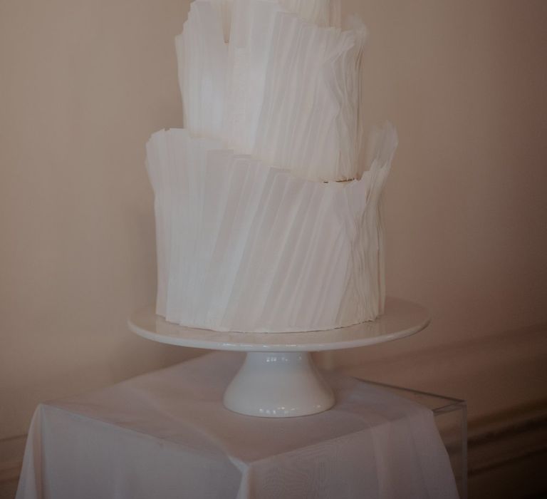 Three tiered buttercream wedding cake with white textured icing 