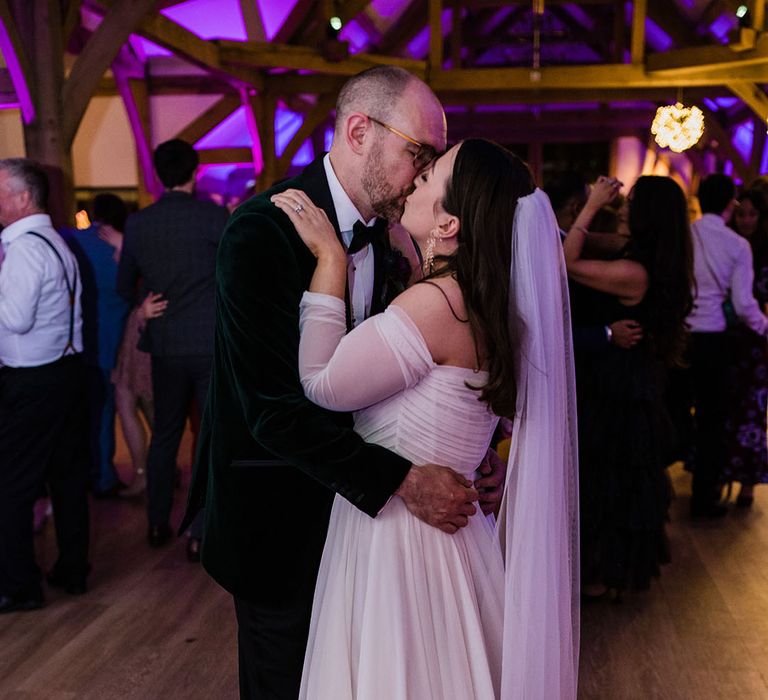 The bride and groom share an intimate kiss as they share their first dance together 