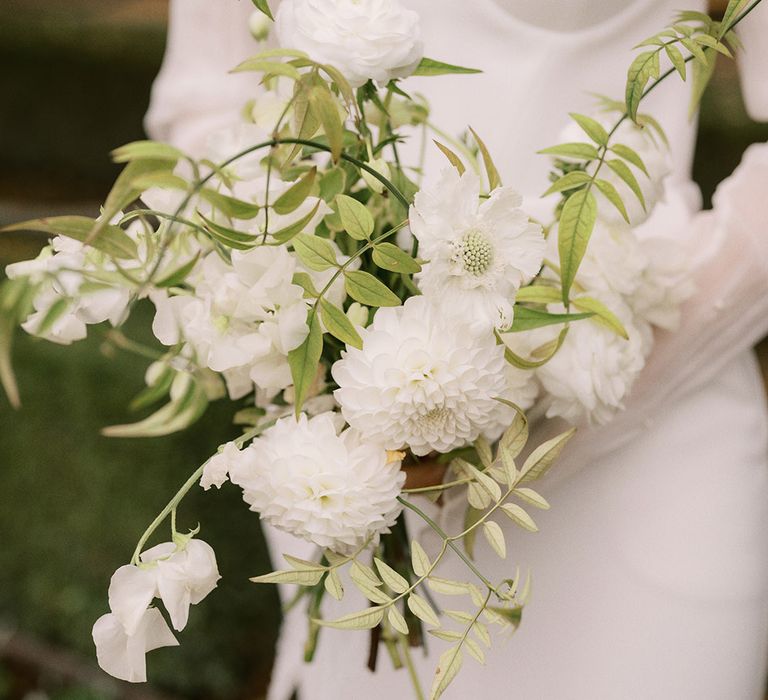 White dahlias and sweet peas wedding bouquet for the bride in a strapless wedding dress from Bon Bride 