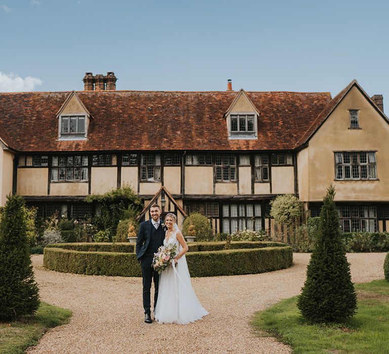 Dove Barn Weddings venue in Suffolk with the bride and groom standing in front of the wedding venue 