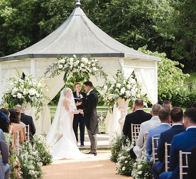 Outdoor wedding ceremony in a gazebo at The Manor House, Castle Combe wedding venue 