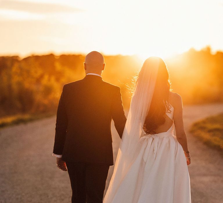 Stunning golden hour couple portrait of the bride and groom at their autumnal wedding 