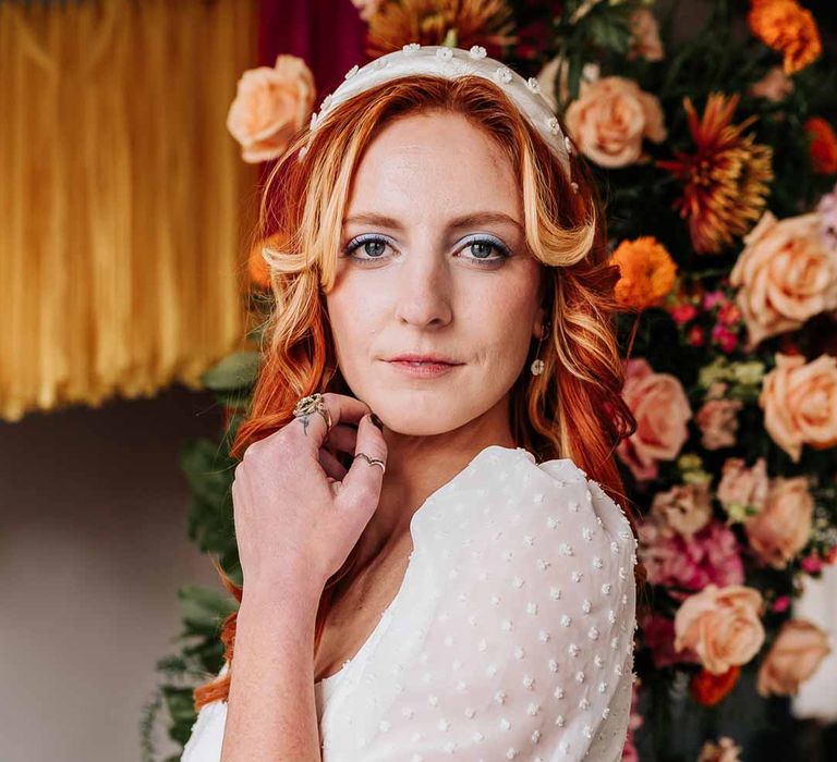 Bride in three quarter length puff sheer sleeve wedding dress with delicate polka dot overlay and square neck and white 3D applique polka dot headband and silver wedding jewellery at Northern Monk Refectory Leeds  