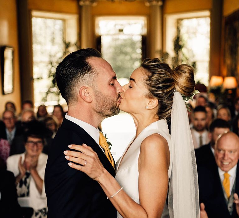 The bride and groom share their first kiss as a married couple 