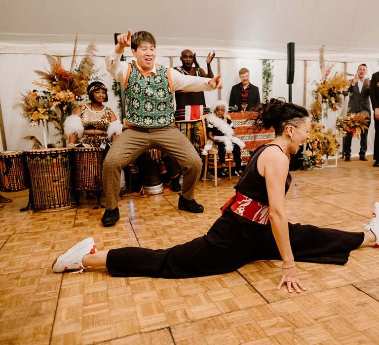 Bride in black bridal jumpsuit doing the splits during last dance wedding song at Broadfield Court wedding