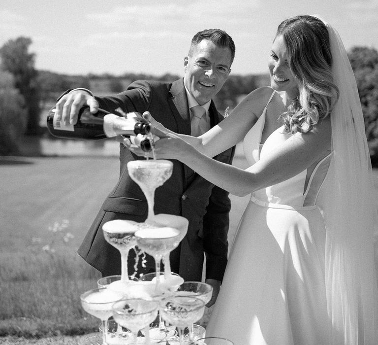 Bride and groom with their epic champagne tower wedding decoration 