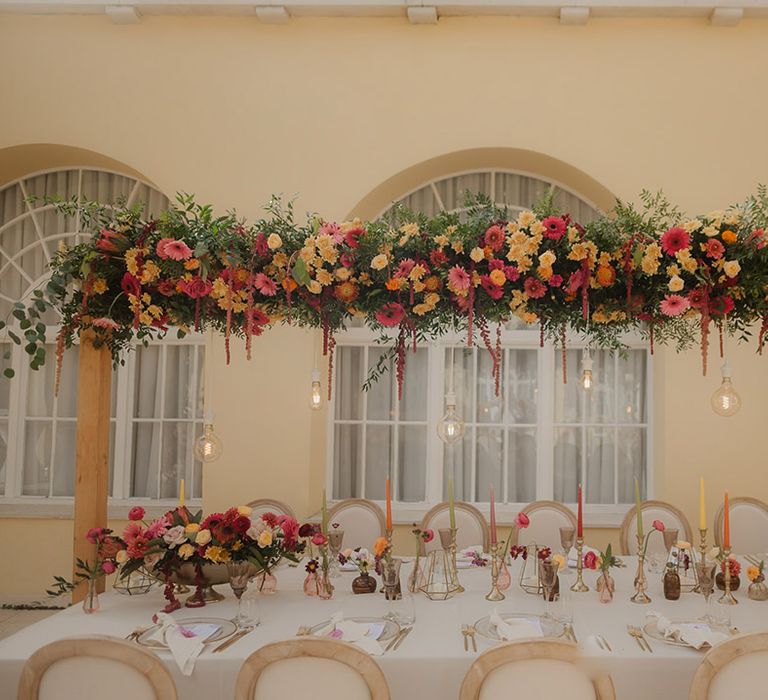 vibrant pink, yellow, red and orange top table wedding flowers and table decorations 