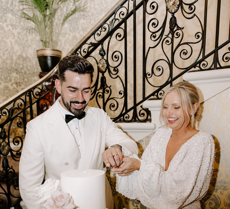 Bride in sparkly wedding reception dress with groom in white suit jacket 