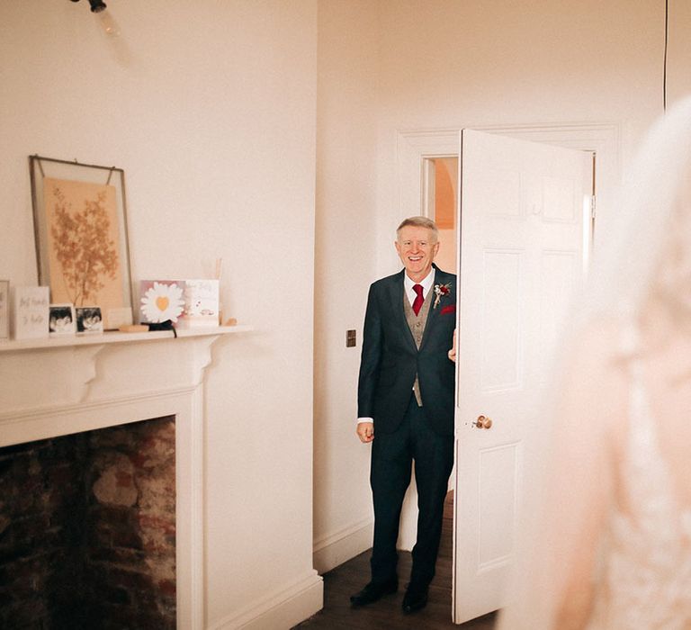 Father of the bride in a navy and grey wedding suit with red details 