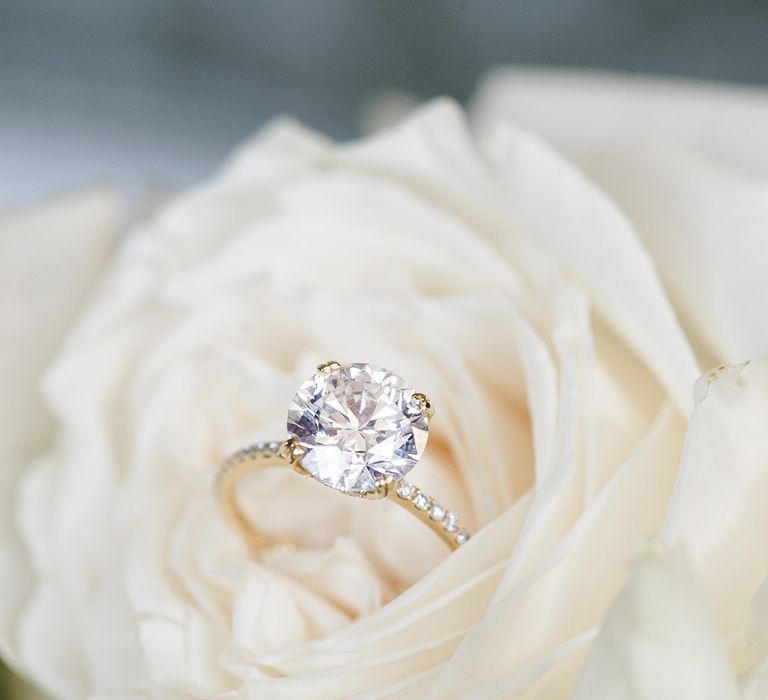 White rose with a round clear brilliant diamond engagement ring 