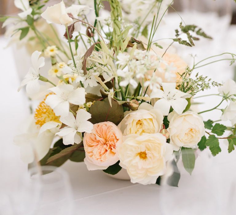 White and peach neutral wedding flower decorating the table 